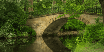 Historische Steinbrücke in einem grünen Park