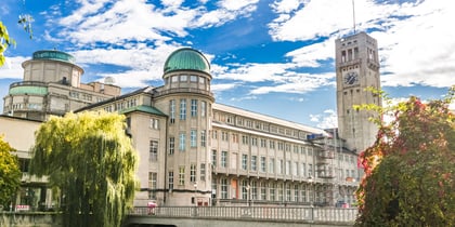 Historisches Gebäude mit Barometerturm in Hamburg unter blauem Himmel.