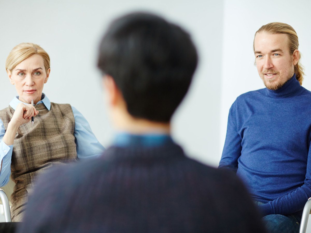 Coaching-Gespräch mit zwei Teilnehmenden in einer Gesprächsrunde