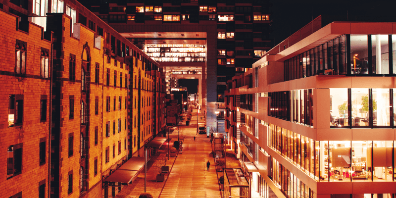 The Cologne Crane Houses (Kranhäuser) and modern office buildings illuminated at night in the Rheinauhafen district of Cologne, Germany
