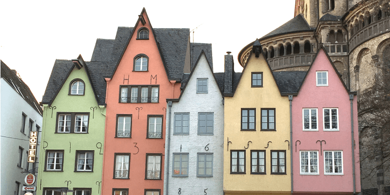 Colorful historic houses in Cologne's Old Town with part of the Great St. Martin Church visible in the background, Germany.