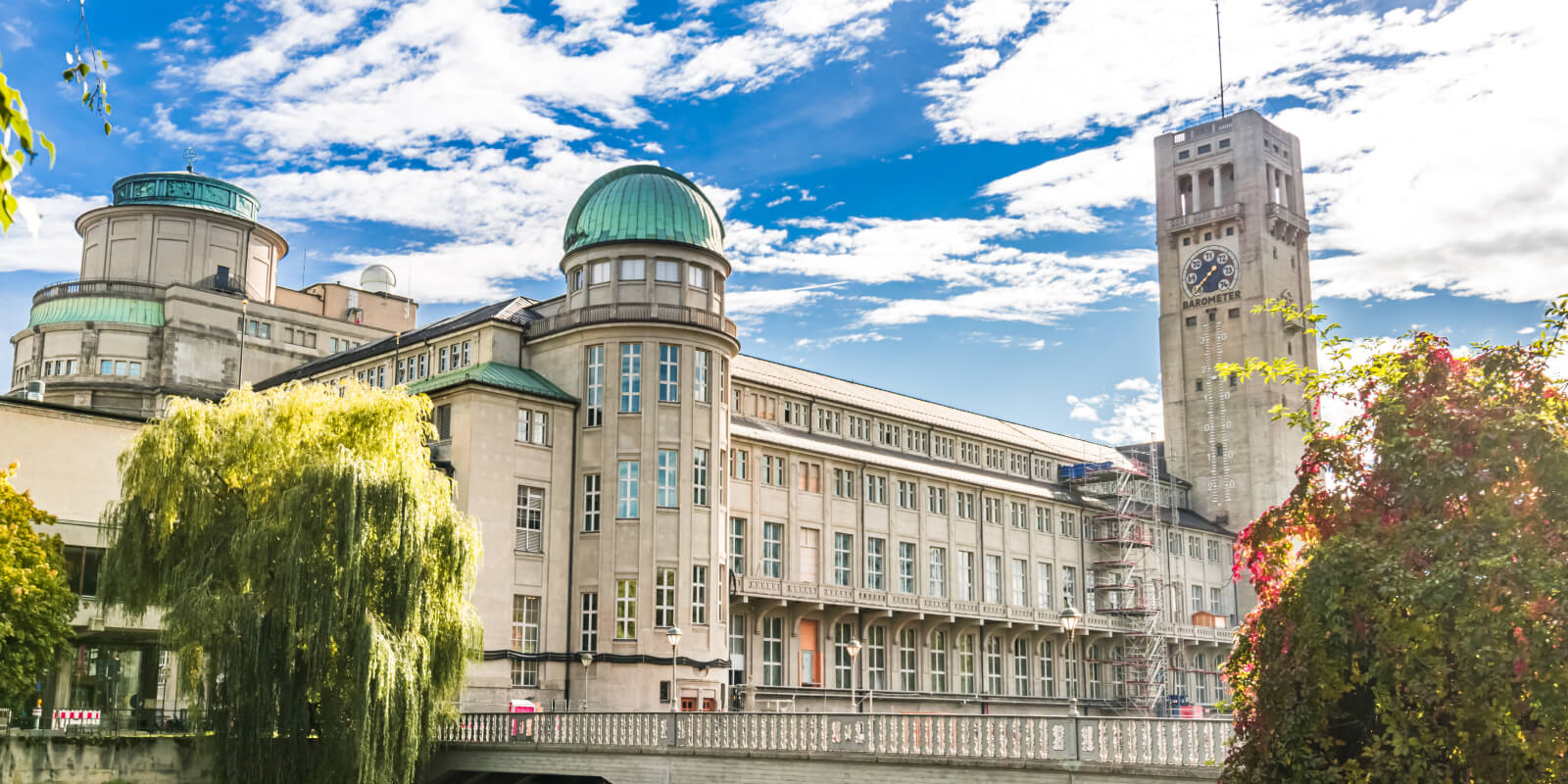 Historisches Gebäude mit Barometerturm in Hamburg unter blauem Himmel.